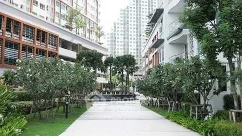 Modern residential complex with lush greenery and contemporary architecture.