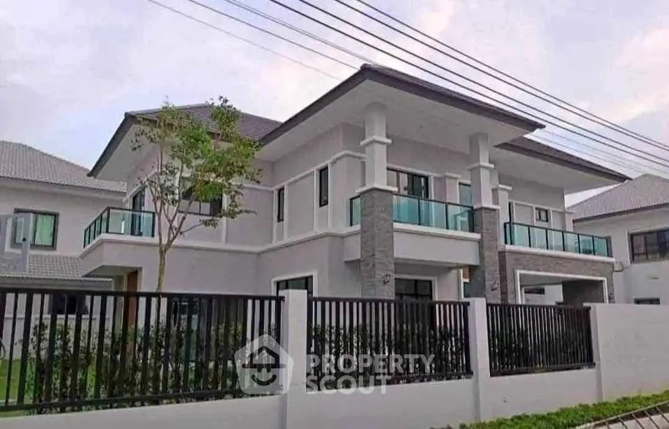 Modern two-story house with sleek design and spacious balconies in a serene neighborhood.