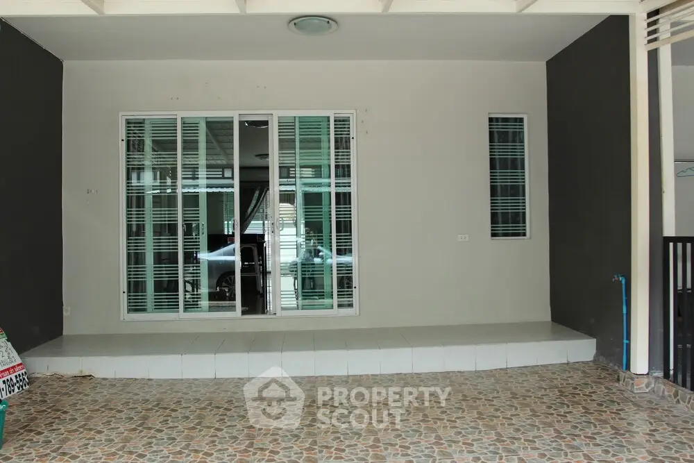 Spacious tiled entrance with sliding glass doors and modern design