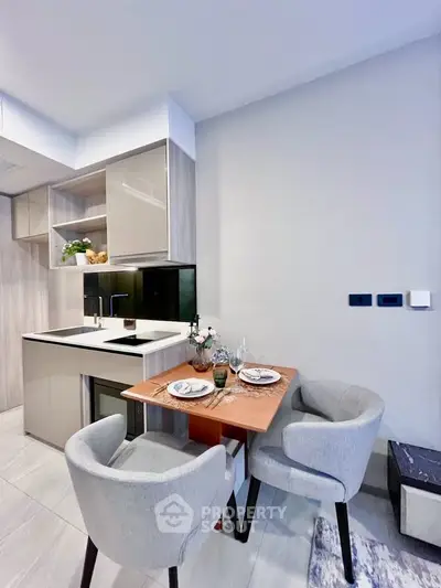 Modern kitchen with sleek cabinetry and cozy dining area in a stylish apartment.