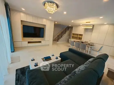 Luxurious modern living room with elegant chandelier and spacious open layout.