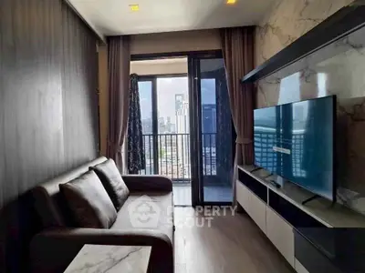 Modern living room with balcony and city view, featuring sleek furniture and large TV.