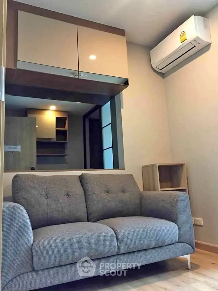 Modern living room with cozy gray sofa and air conditioning unit, perfect for relaxation.