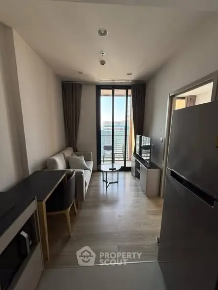 Modern living room with balcony view, featuring sleek furniture and natural light.