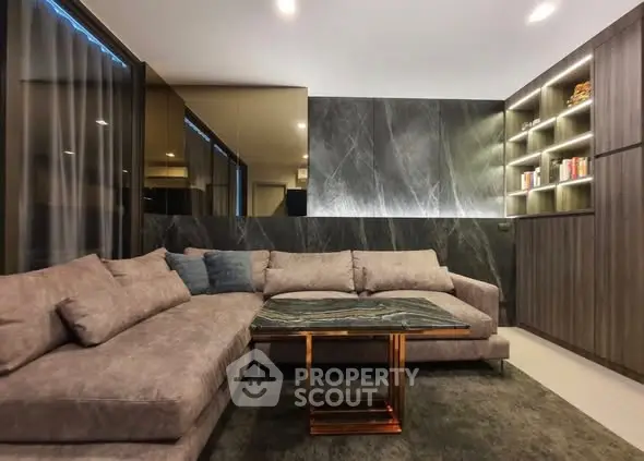 Luxurious modern living room with elegant sectional sofa and stylish shelving.