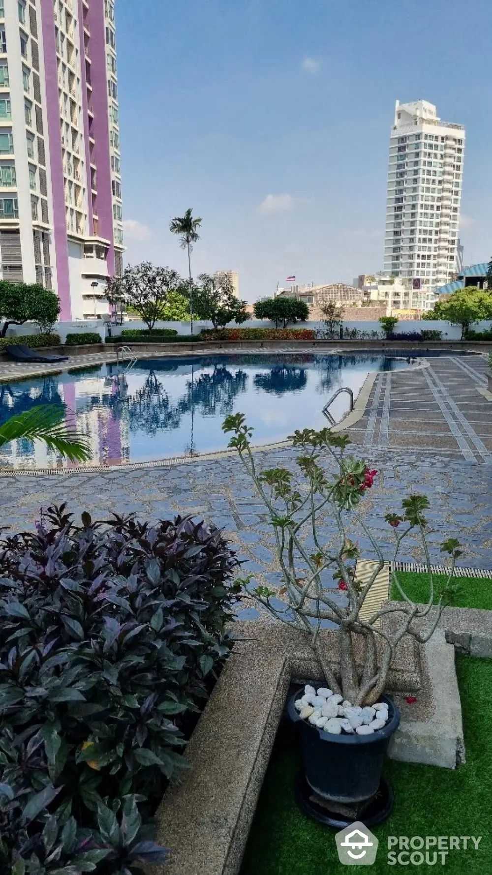 Luxurious high-rise condominium complex with a stunning outdoor pool, lush landscaping, and modern architecture, offering an urban oasis in a prime location.