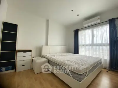 Spacious bedroom with natural light and modern furnishings in a stylish apartment.