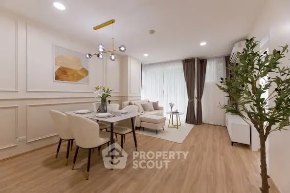 Elegant modern living room with dining area, featuring stylish decor and natural light.