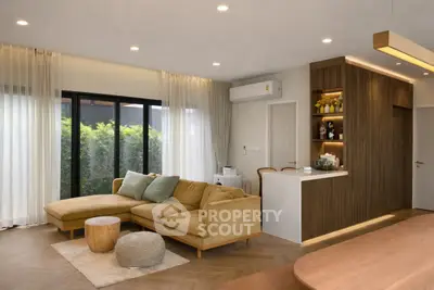 Modern living room with stylish decor and natural light, featuring a cozy sofa and elegant wooden accents.