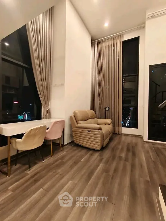 Luxurious high-ceiling living room with elegant decor and city view.