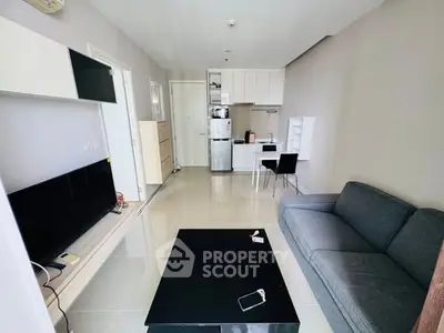 Modern living room with sleek furniture and open kitchen layout in a stylish apartment.