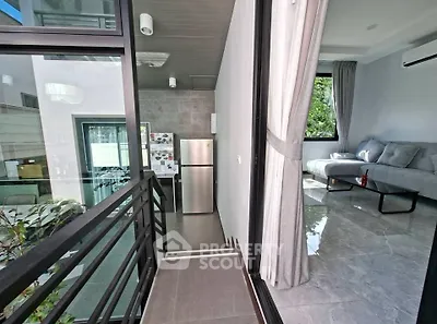 Modern apartment with sleek kitchen and cozy living room, featuring large windows and stylish decor.