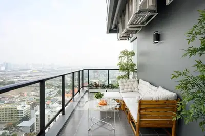 Spacious balcony with city view, modern seating, and lush greenery for a perfect urban retreat.