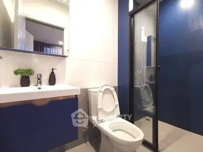 Modern bathroom with sleek blue accents and glass shower enclosure