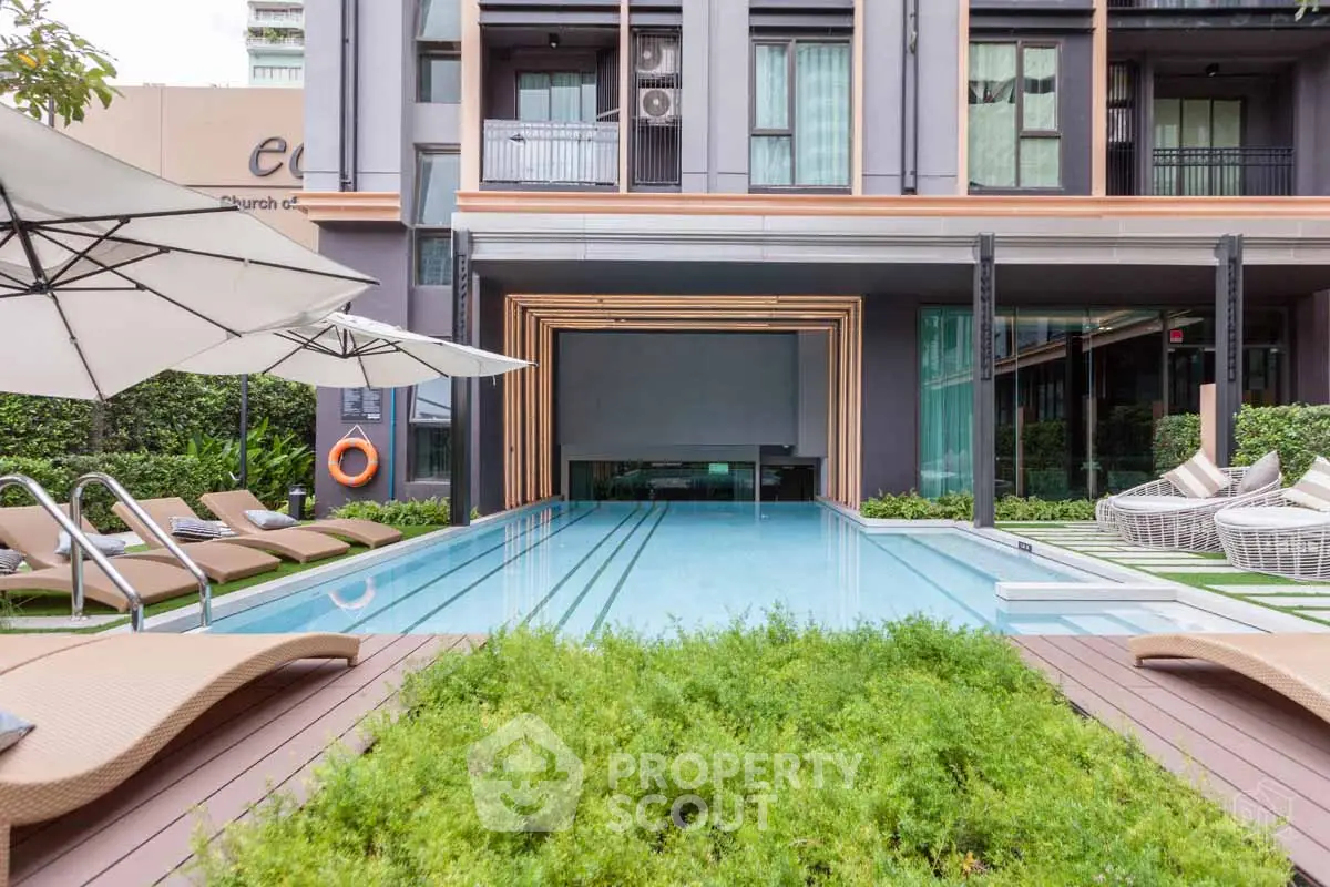 Luxurious modern apartment complex with inviting poolside and stylish outdoor seating.