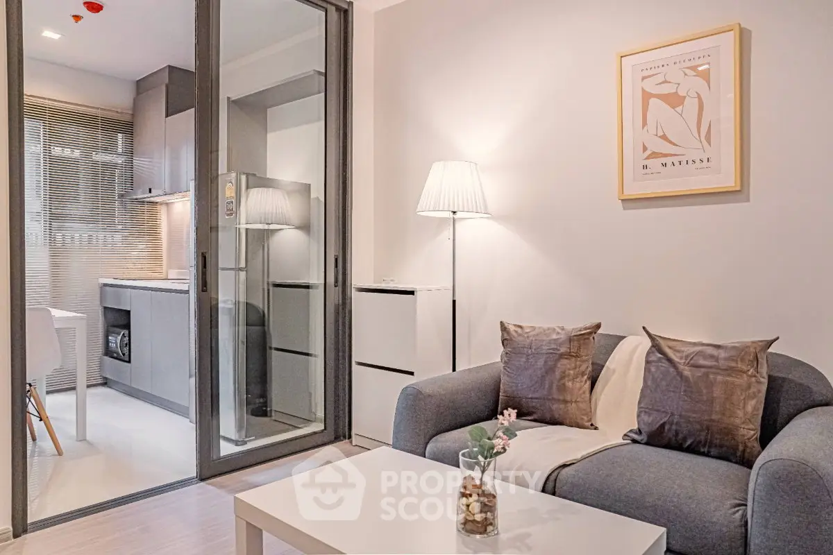 Modern living room with cozy sofa and stylish kitchen in open layout apartment.