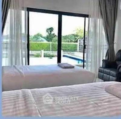 Spacious bedroom with pool view and large windows for natural light