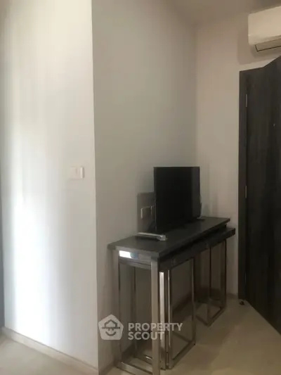 Modern minimalist interior with sleek TV stand and wall-mounted air conditioner.