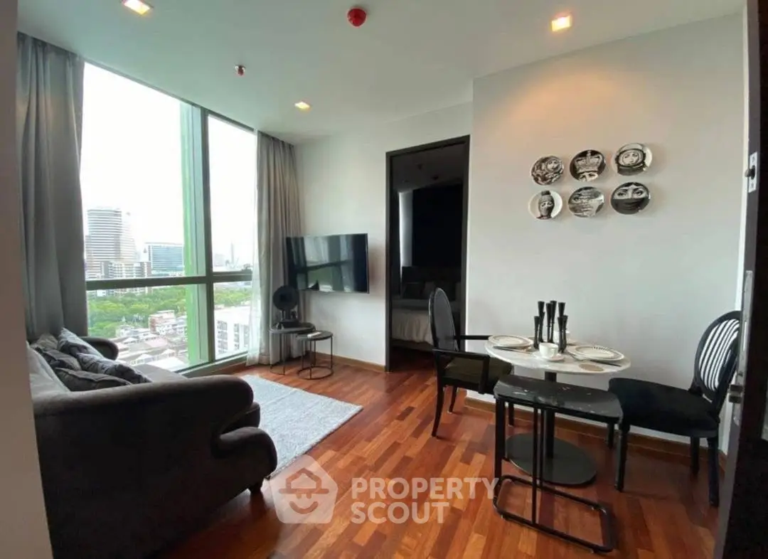 Modern living room with city view, stylish decor, and cozy dining area in a high-rise apartment.