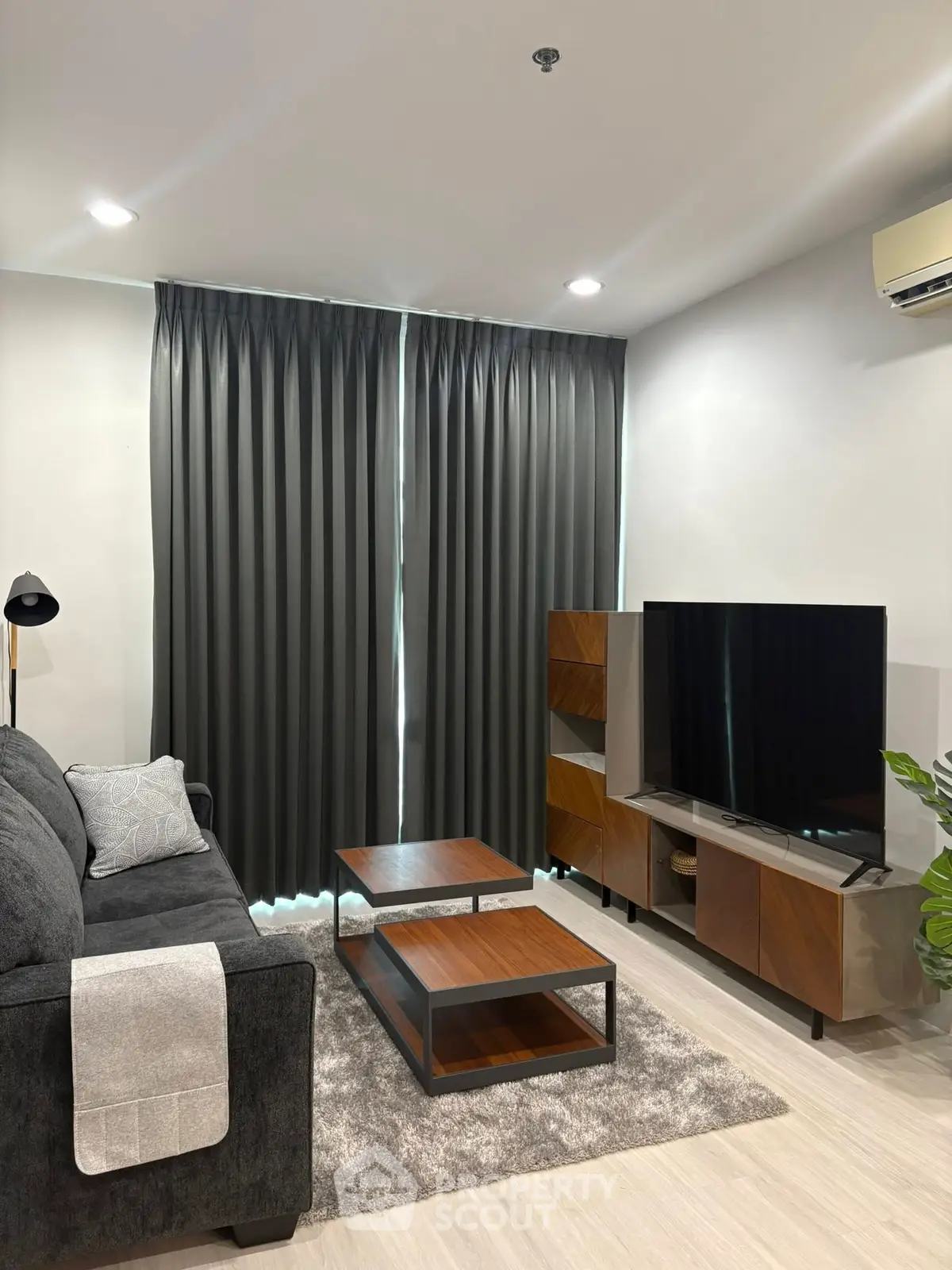 Modern living room with sleek furniture and large TV, perfect for relaxation and entertainment.