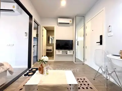 Modern living room with sleek design, featuring a TV, air conditioning, and stylish decor in a cozy apartment.