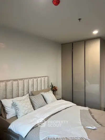 Cozy bedroom with elegant decor and spacious wardrobe in modern apartment.