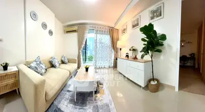 Spacious living room with modern decor and large window view.