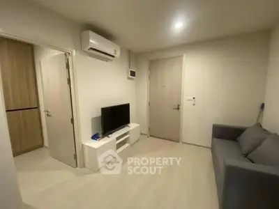 Cozy living room with modern furniture and TV, perfect for relaxation.