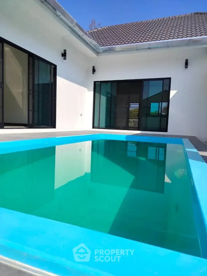 Modern home with private pool and sleek glass doors, perfect for luxury living.