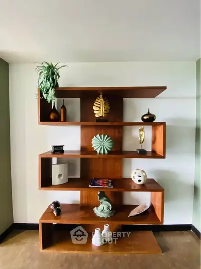Stylish wooden shelving unit with decorative items in modern living room.