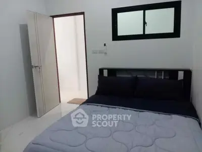 Cozy bedroom with modern decor and natural light, perfect for relaxation.