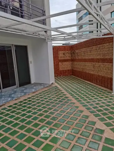Spacious outdoor terrace with unique tile design and modern railing, perfect for relaxation and entertainment.