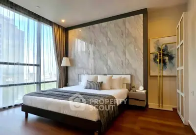 Luxurious bedroom with modern decor and large windows offering natural light and city views.