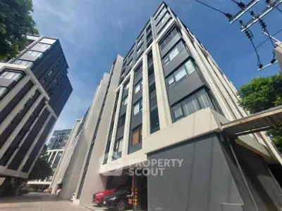 Modern high-rise apartment building with sleek design and urban surroundings.