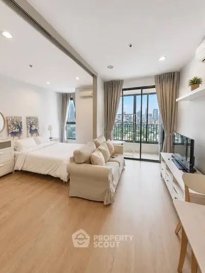 Spacious studio apartment with modern decor and city view balcony