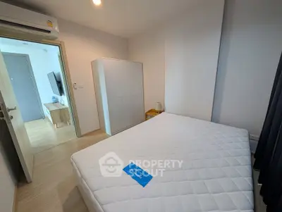 Modern bedroom with minimalist design and natural light, featuring a comfortable bed and sleek wardrobe.