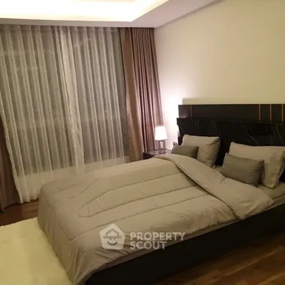 Elegant bedroom with modern decor and cozy lighting, featuring a plush bed and stylish curtains.