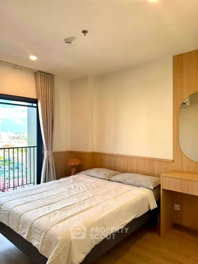 Cozy bedroom with city view and modern furnishings in a high-rise apartment.