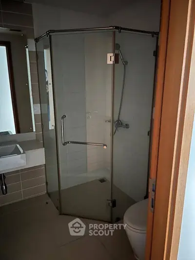 Modern bathroom with glass shower enclosure and sleek fixtures.