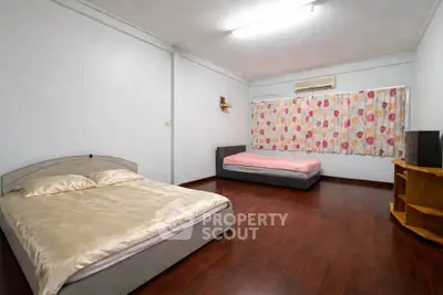 Spacious bedroom with two beds and wooden flooring, ideal for comfort and relaxation.