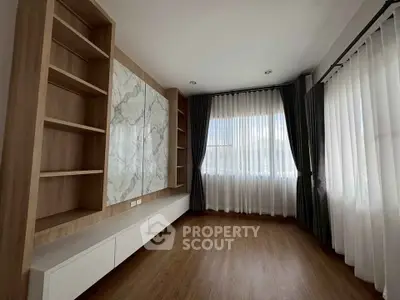 Spacious modern living room with elegant wood flooring and large windows for natural light.