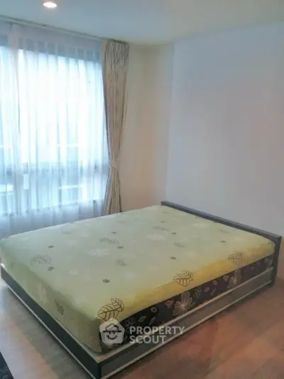 Cozy bedroom with large window and stylish bed in modern apartment