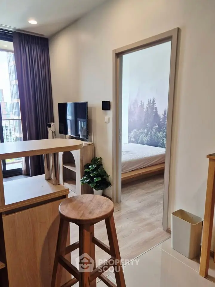 Modern apartment interior with open layout, featuring a cozy living area and a glimpse into a serene bedroom.
