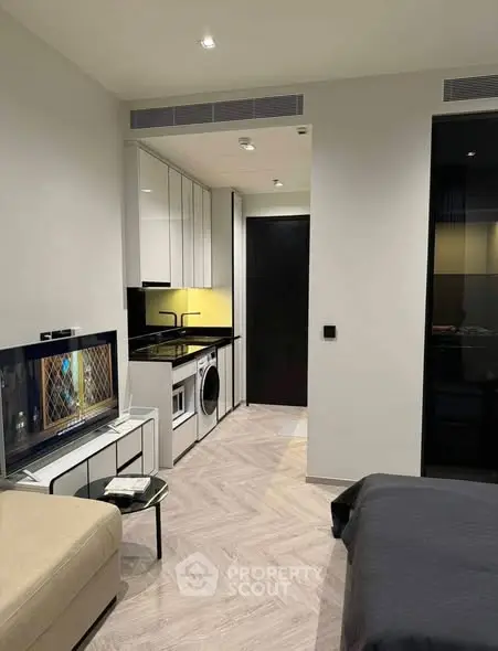 Modern studio apartment with sleek kitchen and cozy living area, perfect for urban living.
