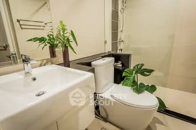 Modern bathroom with sleek fixtures and lush green plants for a refreshing ambiance.