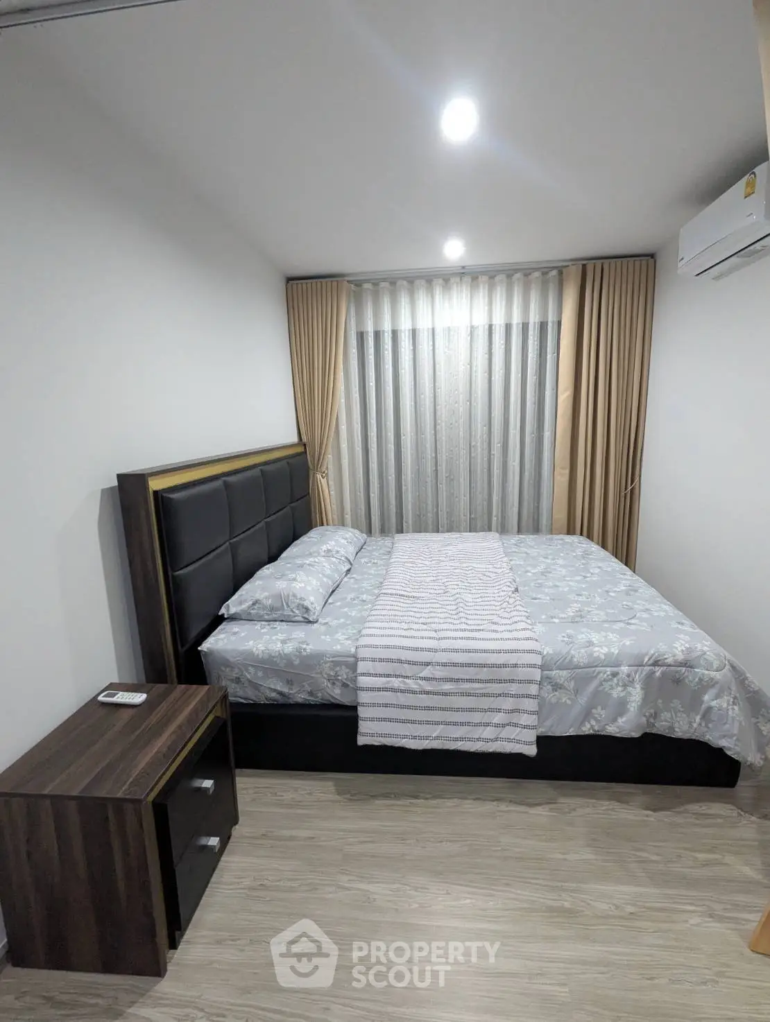 Cozy bedroom with modern decor, featuring a comfortable bed and elegant curtains, perfect for relaxation.