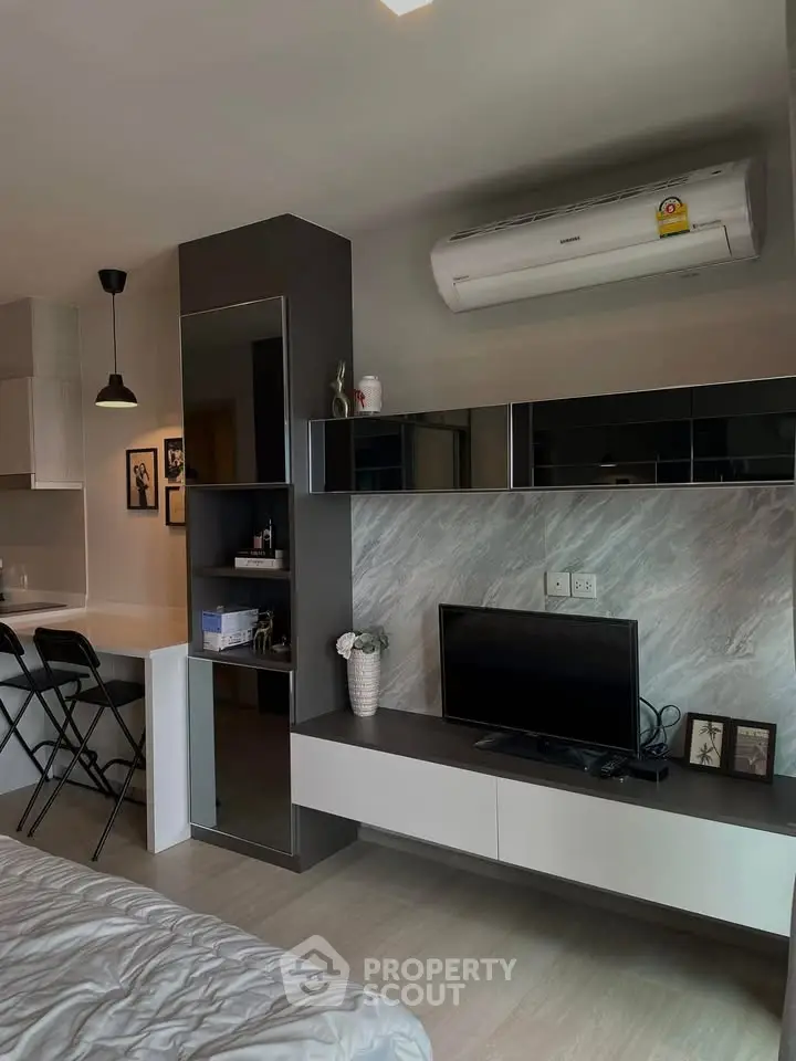 Modern studio apartment with sleek design, featuring a cozy living area and efficient use of space.