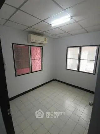 Compact room with tiled floor and air conditioning, ideal for a cozy living space or office setup.