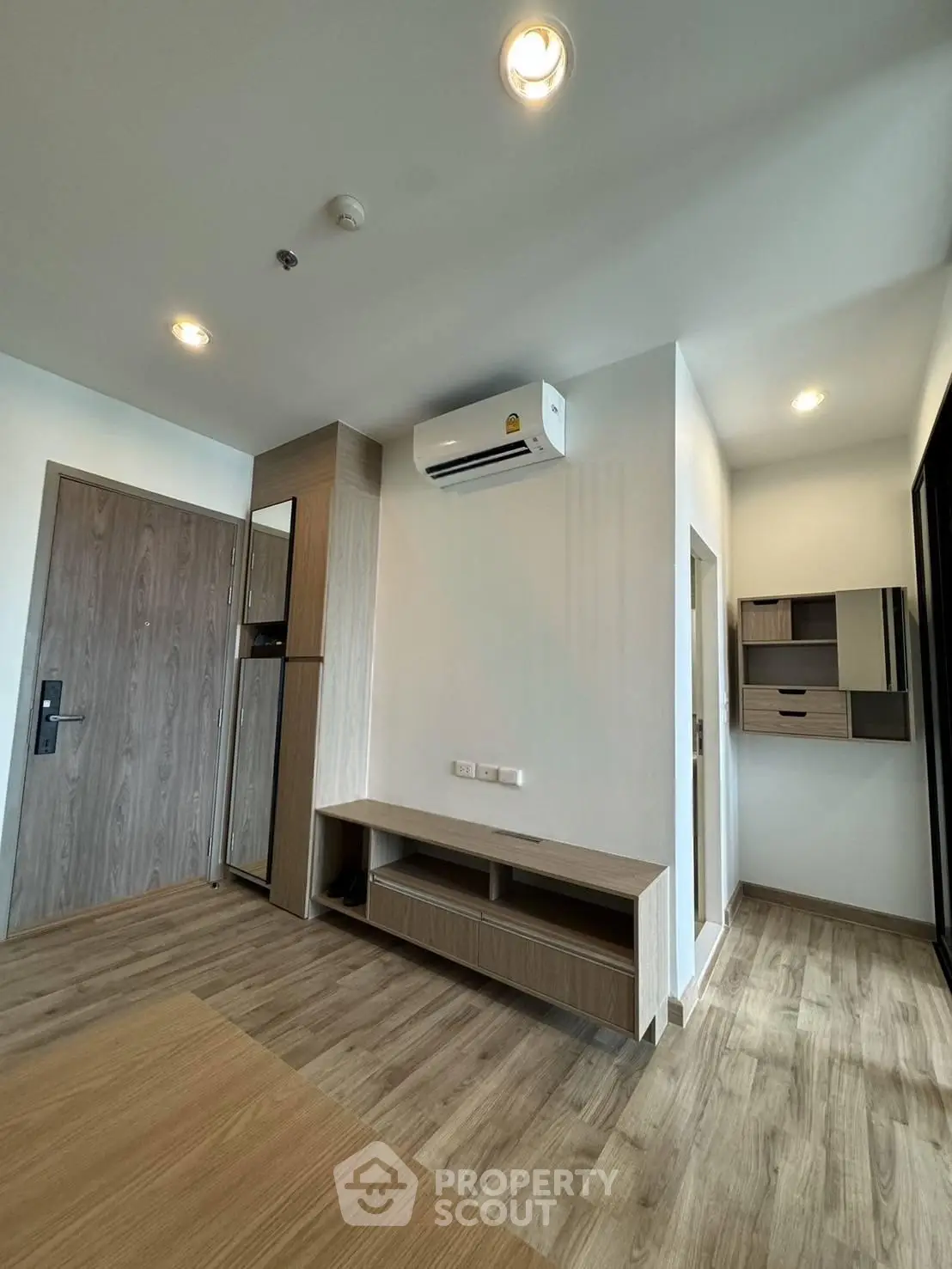 Modern apartment interior with wooden flooring and built-in storage solutions