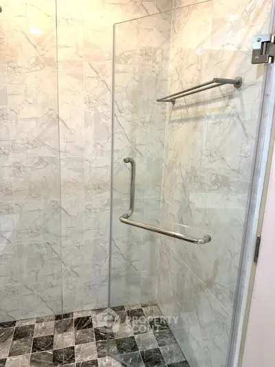 Modern bathroom with marble tiles and glass shower enclosure